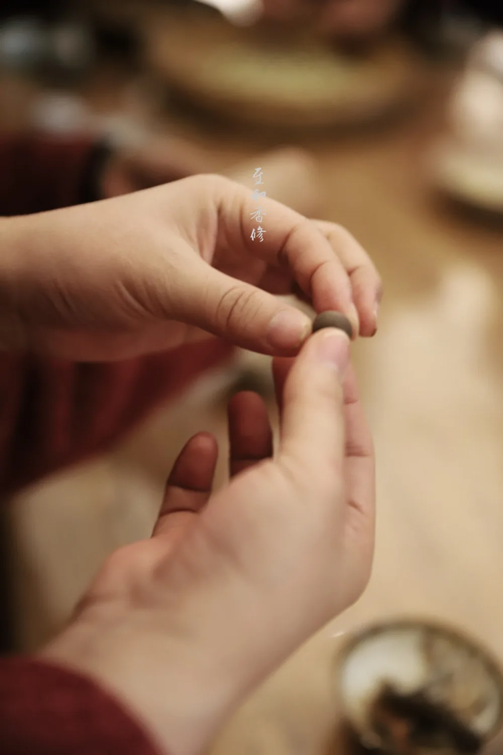 Hands crafting incense beads